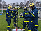 Einsatzkräfte der Fachgruppe Notversorgung und Notinstandsetzung bauen Stative mit Scheinwerfern um die Einsatzstelle herum auf (Foto: THW / M. Braunst).