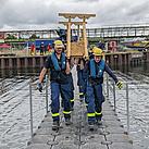THW-Helfer tragen eine selbst gebaute Treppe an das andere Ende der Pontonbrücke  (Foto: THW / M. Braunst).