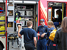 THW-Helferinnen und -Helfer nutzen die Möglichkeit sich über das Fahrzeug der Feuerwehr zu informieren (Foto: THW / C. Pachl).