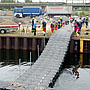 Die fertige Brücke wird mit vereinten Kräften in das Hafenbecken geschoben (Foto: THW / M. Kruse).